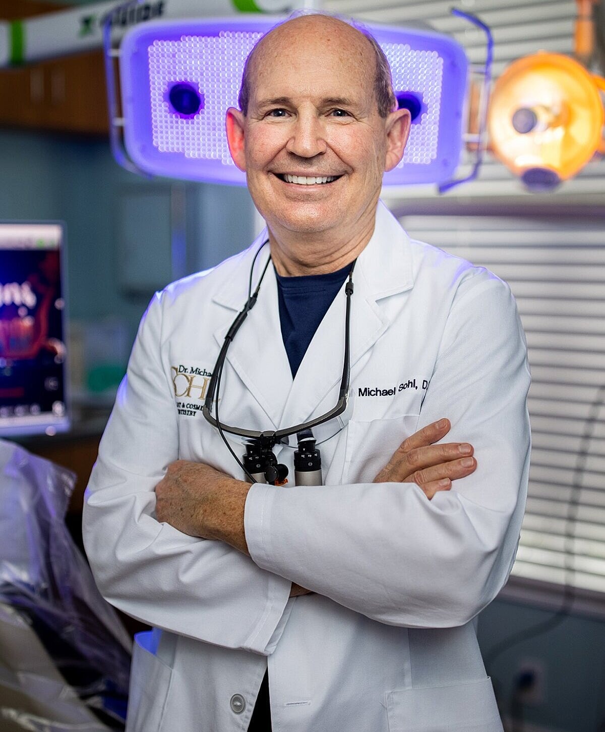 Smiling doctor in a dental office setting.