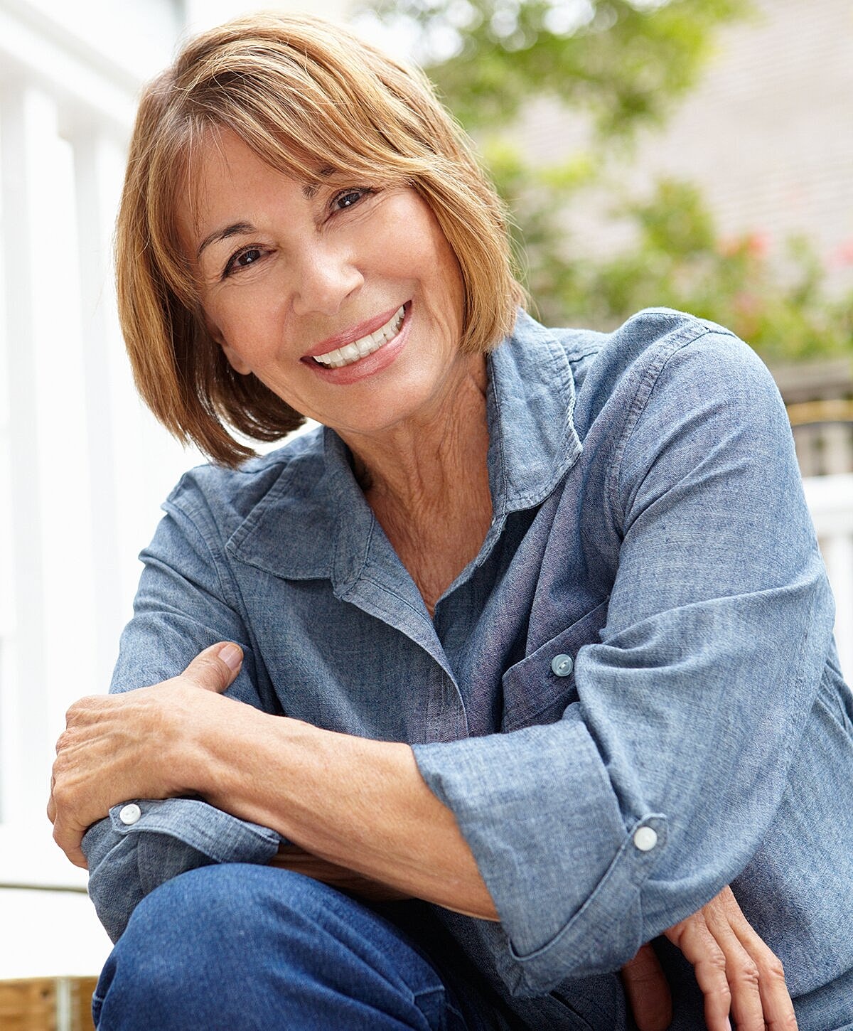 Smiling older woman in casual denim clothing.