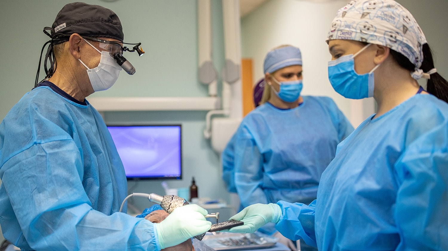 Dental professionals performing a procedure in clinic.