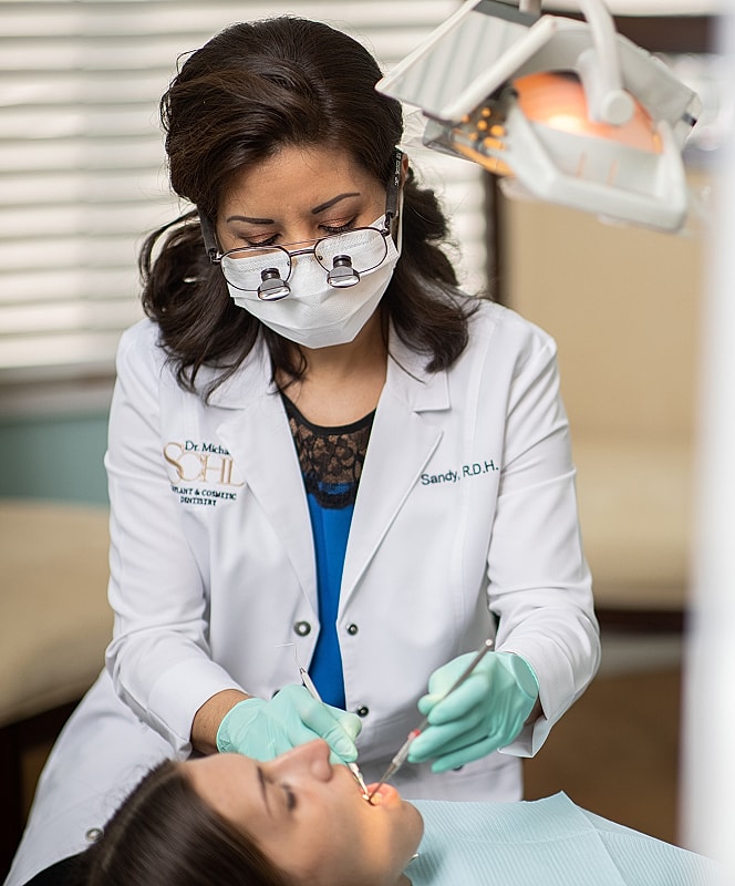 Dental hygienist treating patient in dental clinic.