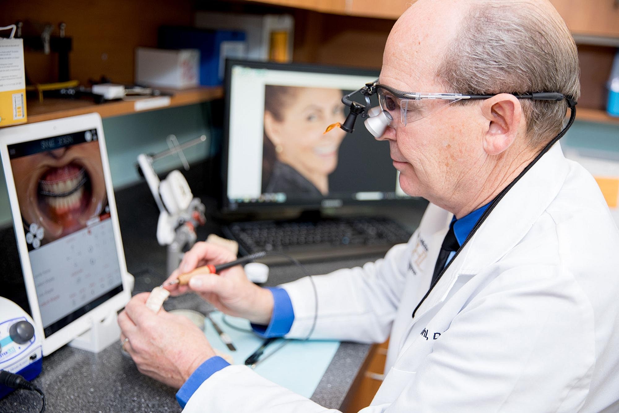 Dentist examining dental impressions with technology.