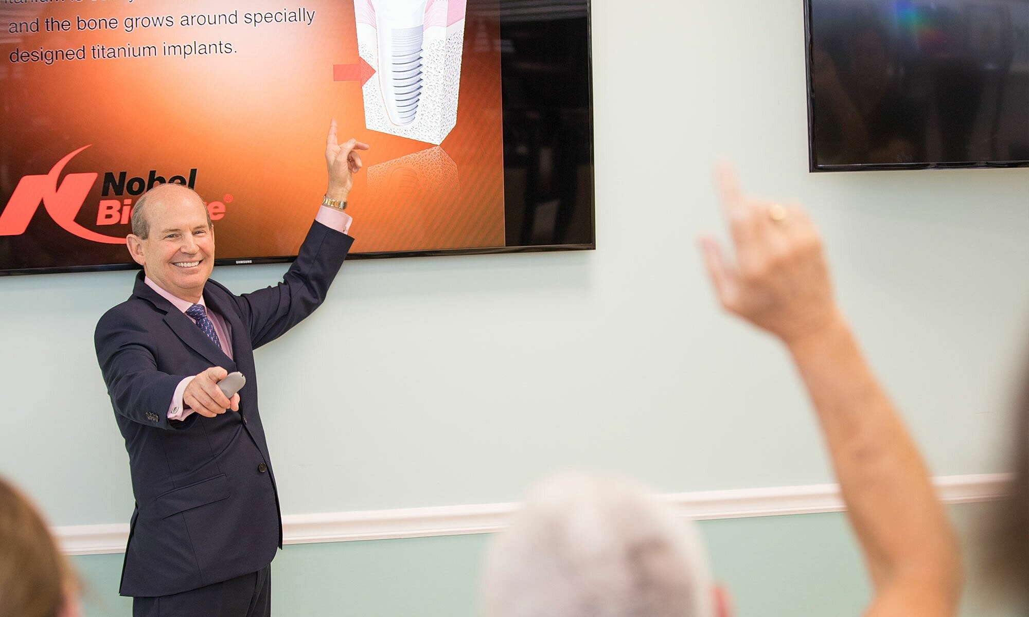 Presenter discussing dental implants in a seminar.