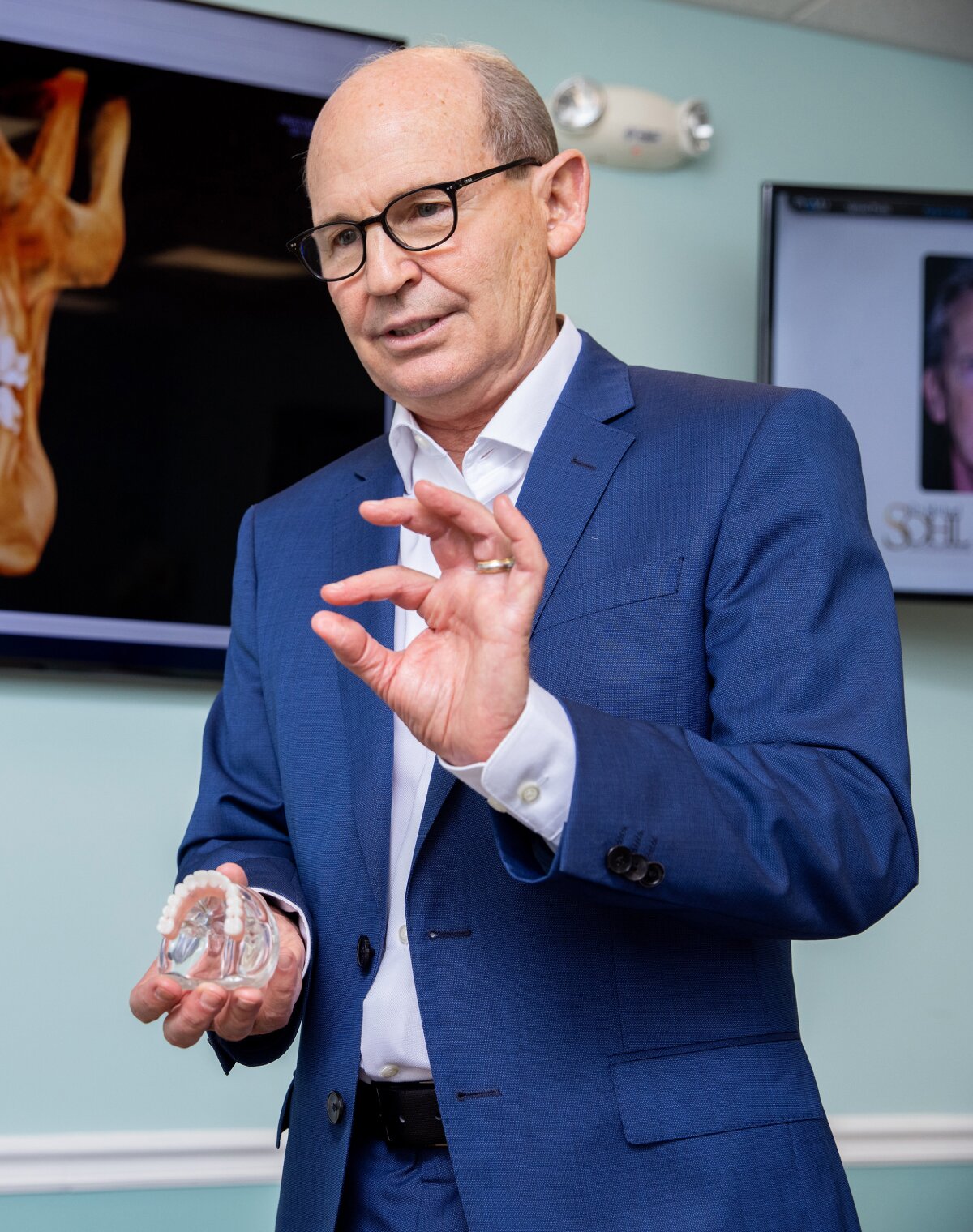 stuart dentist dr. sohl showing a patient a dental implant model